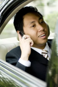 Businessman taking a phone call in the back seat of a car